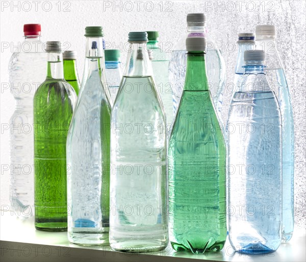 Different varieties of mineral water in bottles made of glass and plastic or PET