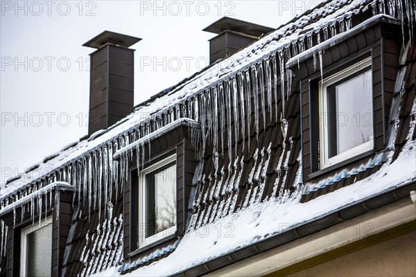 Large icicles hanging from the eaves of a house