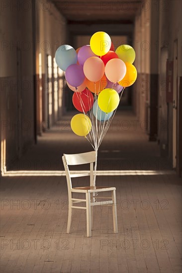 Balloons tied to an old chair