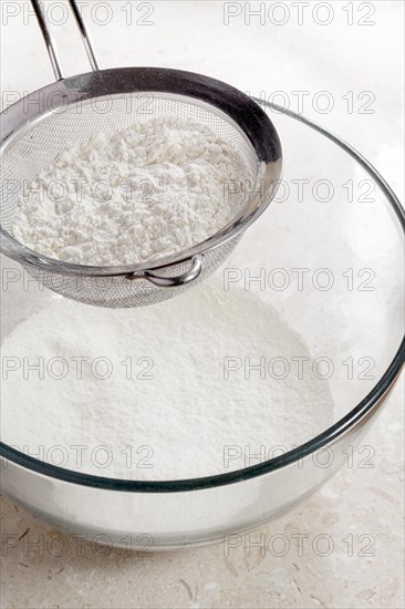 Flour being sieved into bowl