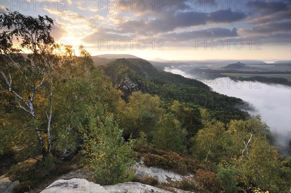 View from the Schrammsteine rocks over the Elbe Valley towards Zirkelstein and Kaiserkrone in autumn at sunrise