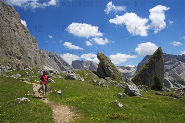 Woman hiking on the Malga Alm alpine pasture below the Odle Mountains