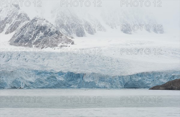 Glacial ice in the rocks surrounding a fjord
