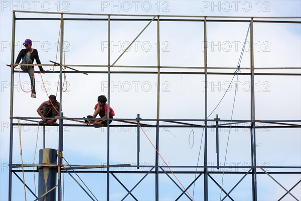 Unsecured workers assembling a scaffold