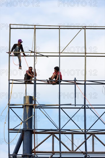 Unsecured workers assembling scaffolding
