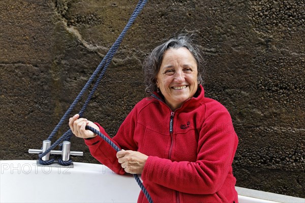 Holidaymaker holding a rope to secure the boat in the lock chamber