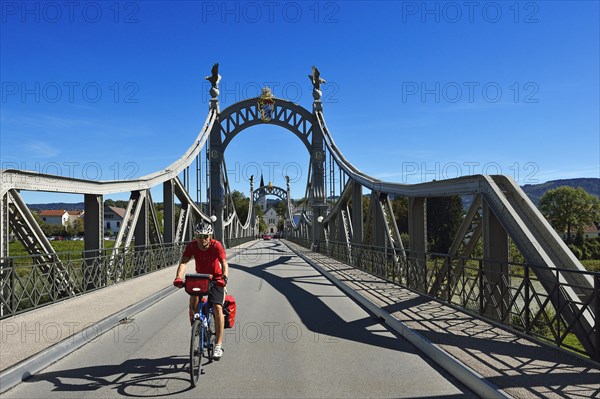 Cyclist crossing Laenderbruecke bridge between Bavaria and Salzburger Land