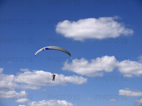 Paragliding in the summer sky with clouds
