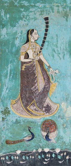 Woman wearing a gilded sari behind peacocks and a lotus pond