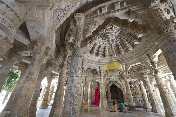 Women sitting in the Interior hall with ornate pillars and ceilings in the marble temple