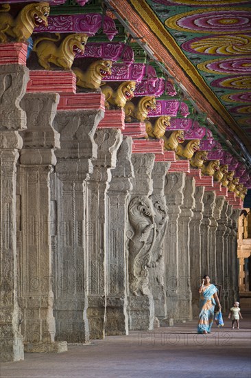 Woman with a child in a hall with brightly painted pillars