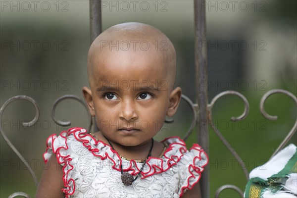 Girl with a shaved head after making a sacrificial offering