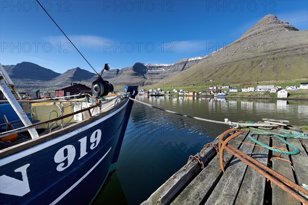 Fishing boat and rusty anchors in the harbour of Hvannasund