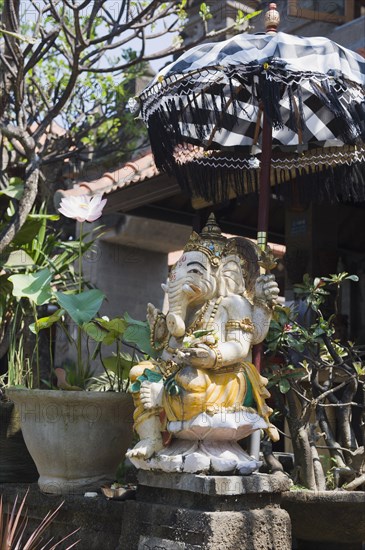 Stone figure of Ganesha with an umbrella