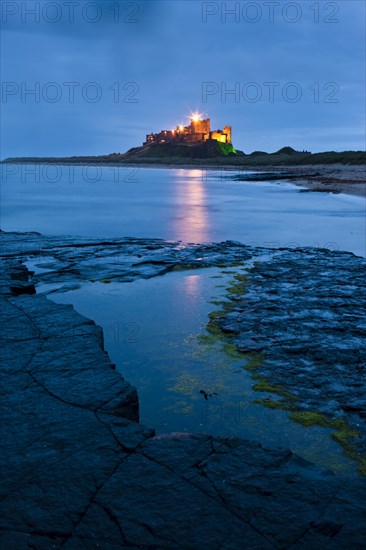 Bamburgh Castle illuminated at dusk