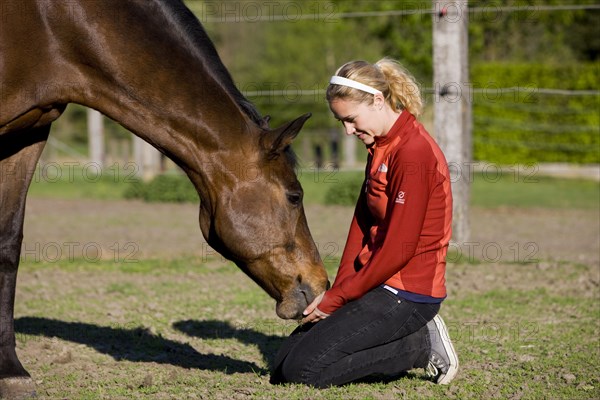 Young woman cuddling an Austrian Warmblood