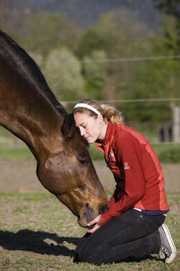 Young woman cuddling an Austrian Warmblood