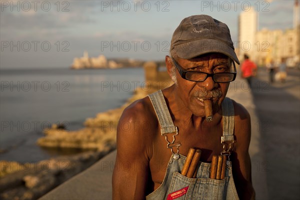 Elderly man with cigars on the Malecón promenade