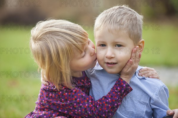 Little girl kissing a little boy