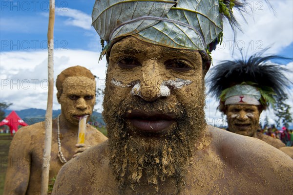 Member of a tribe in a colourfully decorated costume with face and body paint at the traditional sing-sing gathering