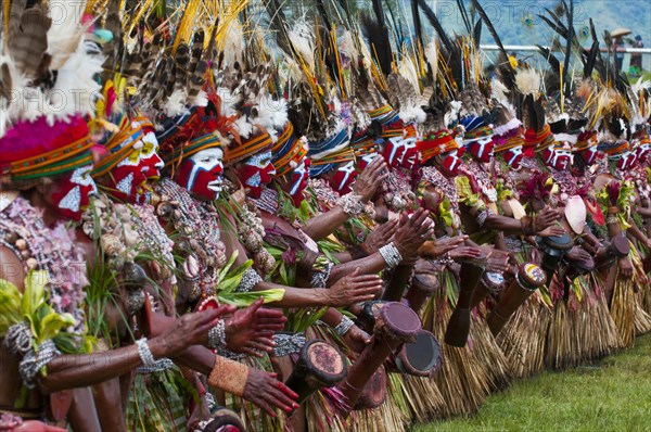 Members of a tribe in colourfully decorated costumes with face paint at the traditional sing-sing gathering