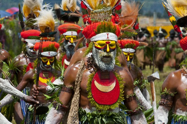 Members of a tribe in colourfully decorated costumes with face paint at the traditional sing-sing gathering