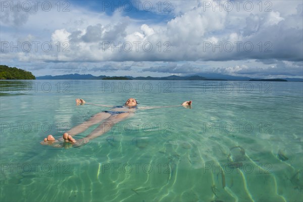 Tourist floating in the clear water of the Marovo Lagoon