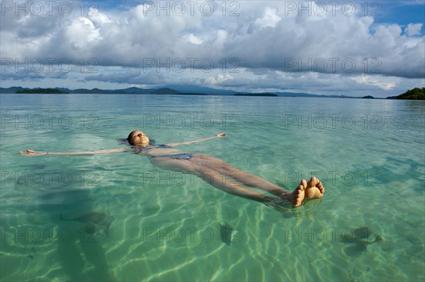 Tourist floating in the clear water of the Marovo Lagoon