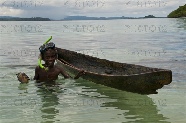 Boy fishing with his canoe and harpoon