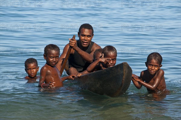 A man and children with a canoe