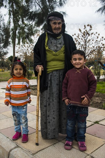 Syrian Orthodox Kurdish woman with tattoos on her face and her grandchildren