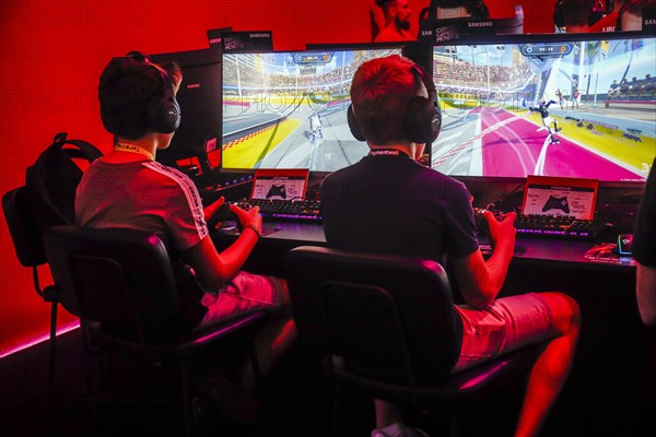 Boys playing computer games in front of screens