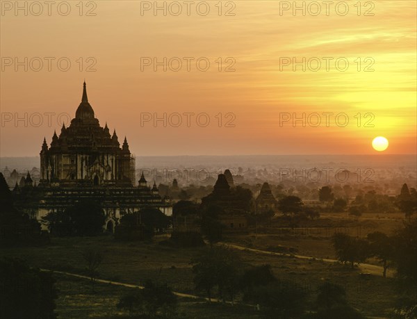 Field with ruins of Buddhist pagodas with Thatbyinnyu Temple at sunset