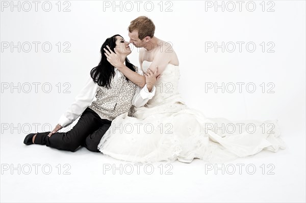 Bride wearing a suit kissing a groom wearing a wedding dress