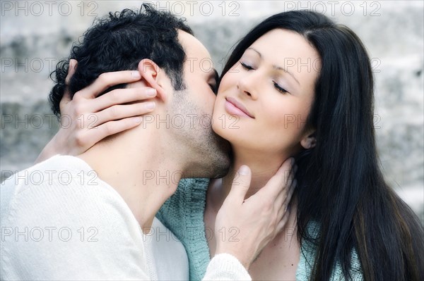 Young man kissing a young woman's neck