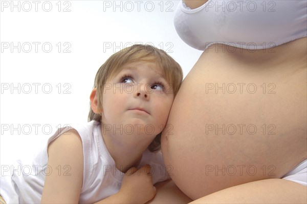 Boy listening to the belly of his pregnant mother