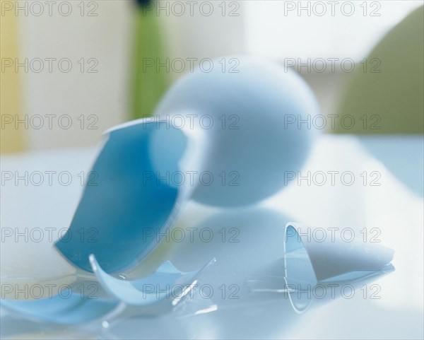 Broken blue vase lying on a glass table