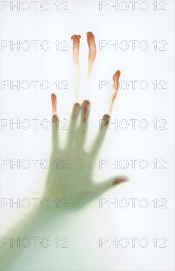 Bloodied hand slipping down frosted glass