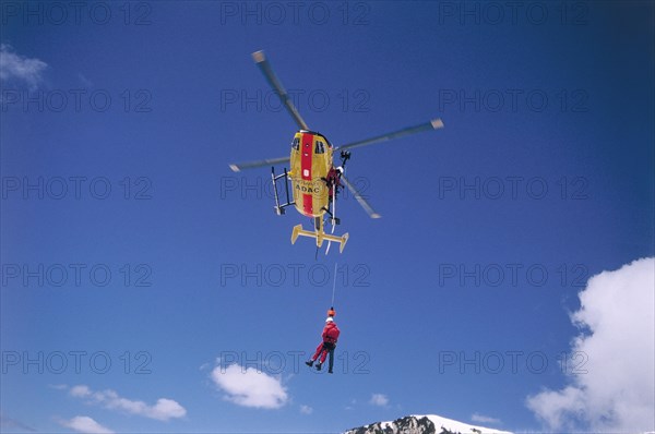 ADAC helicopter during a mountain rescue with a winch