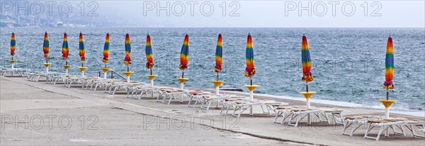 Umbrellas and deckchairs during the preseason on the beach of Opatija on the Mediterranean Sea in Kvarner Bay