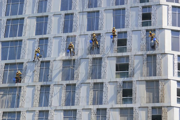 Window cleaners working on the façade of a skyscraper