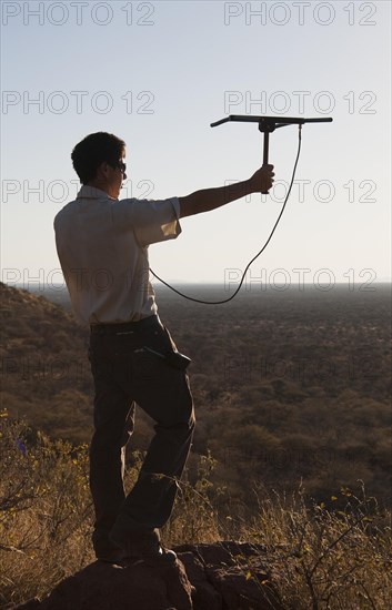 Man locating a leopard with a tracking device