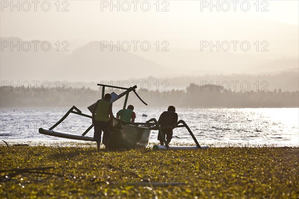 Fisherman with a fishing boat with outriggers