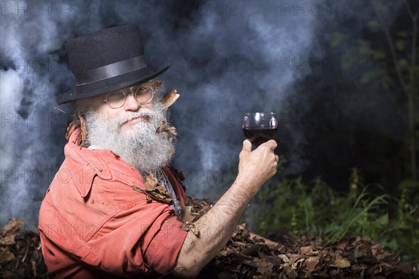 Elderly man with a long beard wearing a top hat and glasses