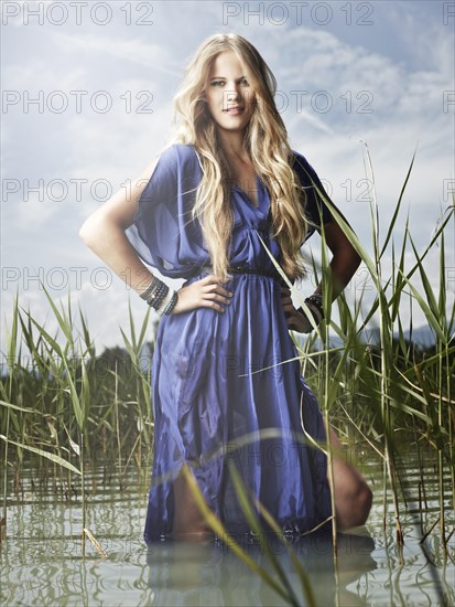 Woman wearing a blue dress standing between the reeds