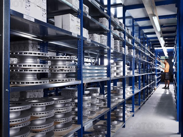 Warehouseman working in the spare parts storage section of a car repair shop