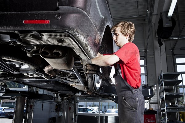 Car mechanic changing tyres in a car repair shop