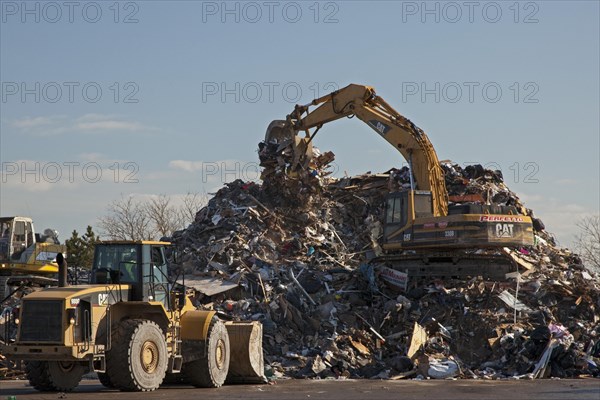 Workers pile debris from Hurricane Sandy in a parking lot next to the beach on Staten Island