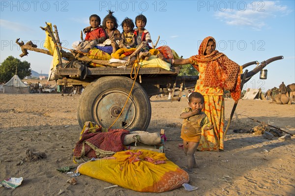 Four children sitting on a camel cart