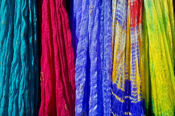 Colourful silk scarves are displayed for sale